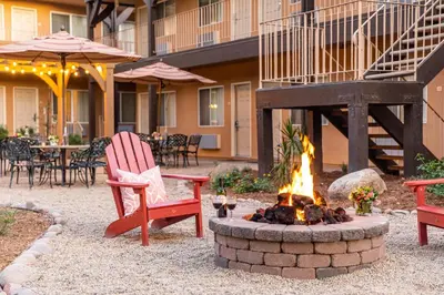 a fire pit in a yard with two chairs and an umbrella at Ayres Lodge Alpine in Alpine