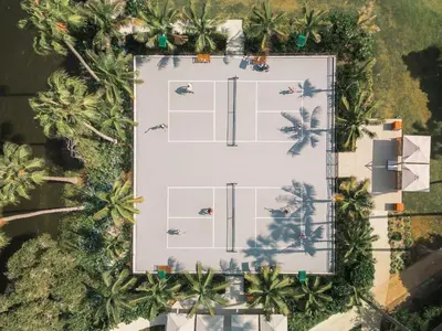 an overhead view of a tennis court with palm trees at La Jolla Beach & Tennis Club in San Diego