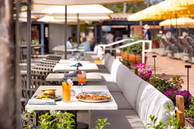 a row of tables with plates of food and drinks at La Jolla Beach & Tennis Club in San Diego