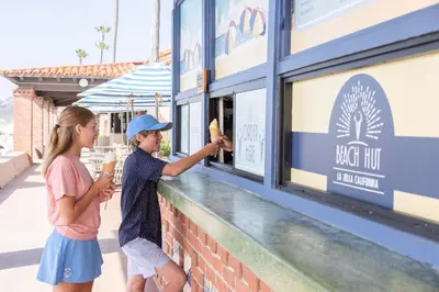 a boy and a girl are standing at a food counter at La Jolla Beach & Tennis Club in San Diego