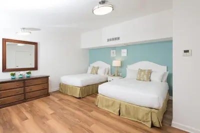 a bedroom with two beds and a mirror at La Jolla Beach & Tennis Club in San Diego