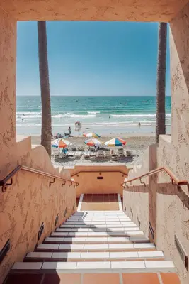 a stairway leading to the beach with umbrellas at La Jolla Beach & Tennis Club in San Diego