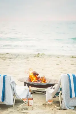a barbecue on the beach with two chairs and two bottles of beer at La Jolla Beach & Tennis Club in San Diego
