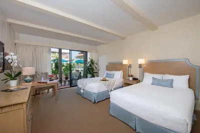 a hotel room with two beds and a desk and a bedroom at La Jolla Shores Hotel in San Diego
