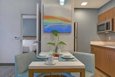 a kitchen with a table and chairs and a kitchen with a painting at Homewood Suites By Hilton Chula Vista Eastlake in Chula Vista