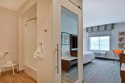 a small bedroom with a bed and a mirror at Hampton Inn Chula Vista Eastlake in Chula Vista