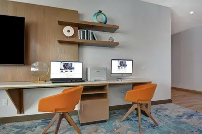 a desk with two computers on it with two chairs at Hampton Inn Chula Vista Eastlake in Chula Vista