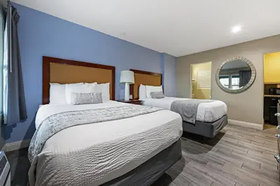a hotel room with two beds and a mirror at Hotel Point Loma in San Diego