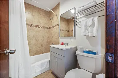 a bathroom with a toilet and a sink and a tub at Hotel Point Loma in San Diego