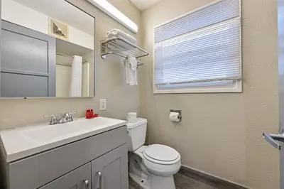 a bathroom with a sink and a toilet and a mirror at Hotel Point Loma in San Diego