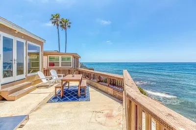 a house with a table and chairs on a balcony overlooking the ocean at Ocean Beach Cliffs Sanctuary Oceanfront in San Diego
