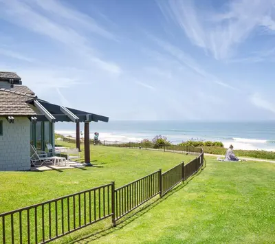 a man sitting on the grass next to a fence at WCH at Wave Crest Resort in Del Mar
