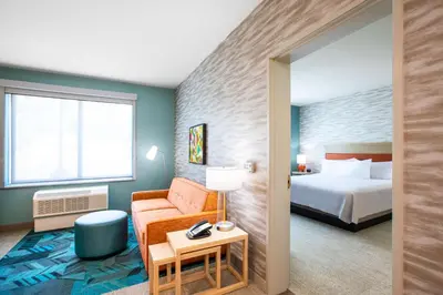 a hotel room with a bed and a chair at Home2 Suites By Hilton Carlsbad, Ca in Carlsbad