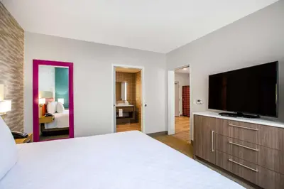a bedroom with a bed and a flat screen tv at Home2 Suites By Hilton Carlsbad, Ca in Carlsbad