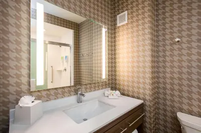 a bathroom with a sink and a mirror at Home2 Suites By Hilton Carlsbad, Ca in Carlsbad