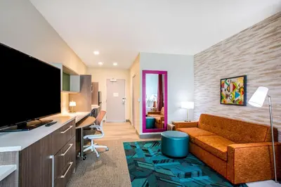a living room with a couch and a desk in a room at Home2 Suites By Hilton Carlsbad, Ca in Carlsbad
