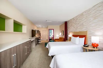 a hotel room with two beds and a kitchen at Home2 Suites By Hilton Carlsbad, Ca in Carlsbad