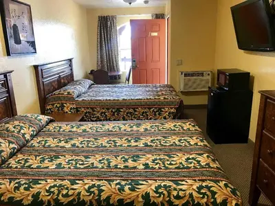 a hotel room with two beds and a flat screen tv at Hacienda Motel in Escondido