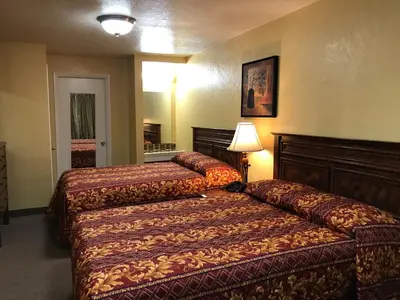 a hotel room with two beds and a lamp at Hacienda Motel in Escondido