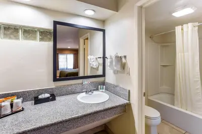 a bathroom with a sink and a toilet and a mirror at Quality Inn Escondido San Diego North County in Escondido