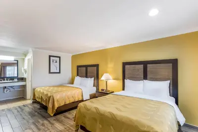 two beds in a hotel room with yellow walls at Quality Inn Escondido San Diego North County in Escondido