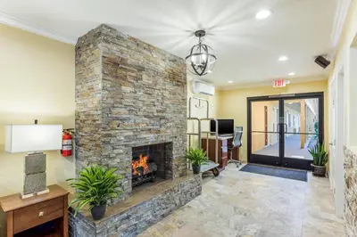 a living room with a large stone fireplace at Quality Inn Escondido San Diego North County in Escondido