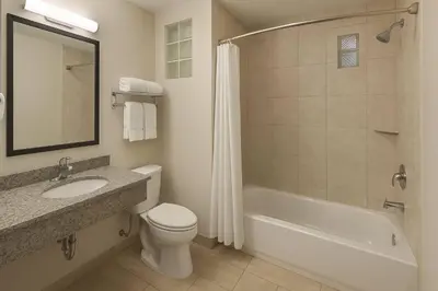 a bathroom with a sink and a toilet and a bath tub at Quality Inn Escondido San Diego North County in Escondido