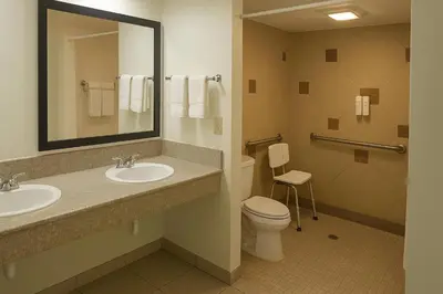a bathroom with two sinks and a toilet and a mirror at Quality Inn Escondido San Diego North County in Escondido