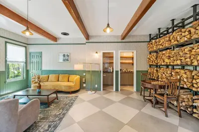a living room with a large stack of logs at Julian Lodge in Julian