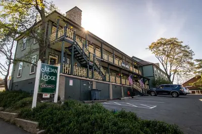 a building with a car parked in a parking lot at Julian Lodge in Julian