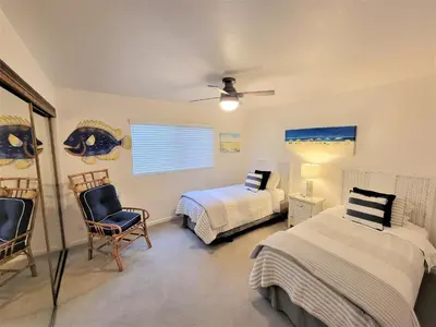 a bedroom with two beds and a chair and a window at Luv Oceanside Views-1 House to Beach, Boardwalk and Waves-Spacious Rooftop Sun Deck-Plus King Beds too! in San Diego