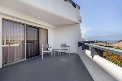 a balcony with chairs and a view of the ocean at The Encinitan Hotel & Suites in Encinitas