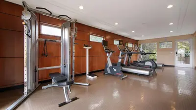 a gym with several treadmills and elliptical machines at The Encinitan Hotel & Suites in Encinitas