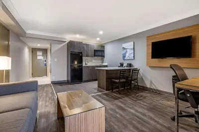 a living room with a couch and a table and a kitchen at The Encinitan Hotel & Suites in Encinitas