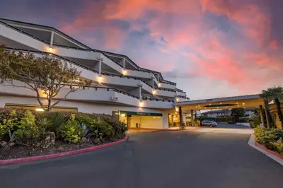 an empty building with a cloudy sky in the background at The Encinitan Hotel & Suites in Encinitas