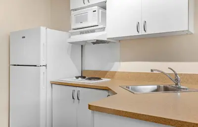 a kitchen with a white refrigerator and a sink at Extended Stay America Suites - San Diego - Carlsbad Village by the Sea in Carlsbad