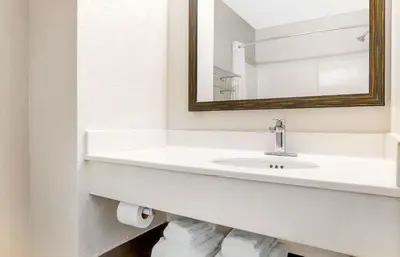 a white bathroom with a sink and a mirror at Extended Stay America Suites - San Diego - Carlsbad Village by the Sea in Carlsbad