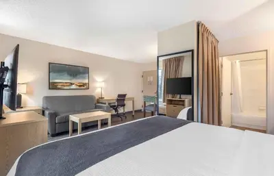 a hotel room with a bed and a living room at Extended Stay America Suites - San Diego - Carlsbad Village by the Sea in Carlsbad