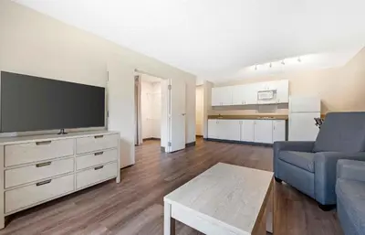 a living room with a couch and a large television at Extended Stay America Suites - San Diego - Carlsbad Village by the Sea in Carlsbad