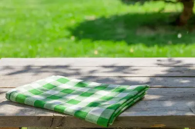 a green and white pillow sitting on a wooden table at Extended Stay America Suites - San Diego - Carlsbad Village by the Sea in Carlsbad