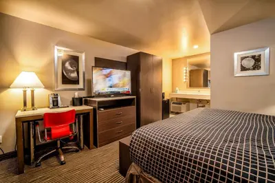 a hotel room with a bed and a desk and a television at Crescent Bay Inn in Laguna Beach