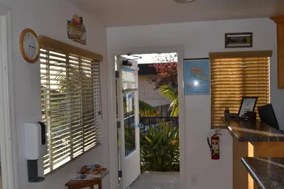 a door to a kitchen with blinds on the window at Moonlight Beach Motel in Encinitas