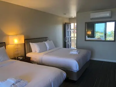 a hotel room with two beds and a window at Moonlight Beach Motel in Encinitas