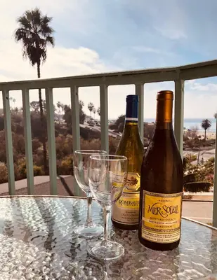 two bottles of wine and two glasses on a table at Moonlight Beach Motel in Encinitas