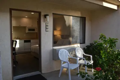 a balcony with two chairs and a table and a kitchen at Moonlight Beach Motel in Encinitas