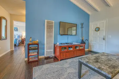 a living room with blue walls and a table and a mirror at Heart of the Village in Carlsbad