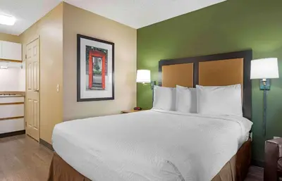 a large white bed in a room with green walls at Extended Stay America Suites - San Diego - Fashion Valley in San Diego