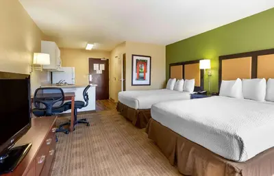 a hotel room with two beds and a desk at Extended Stay America Suites - San Diego - Fashion Valley in San Diego
