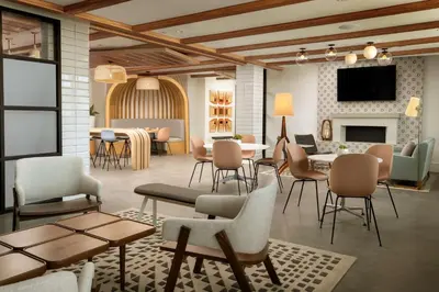 a lobby with tables and chairs and a fireplace at The Monsaraz San Diego, Tapestry Collection By Hilton in San Diego