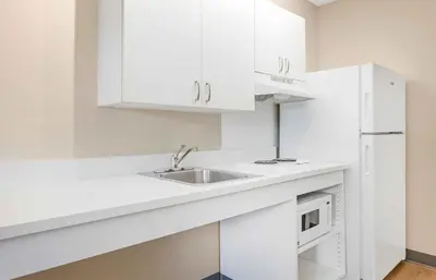 a white kitchen with a sink and a microwave at Extended Stay America Suites - Orange County - John Wayne Airport in Newport Beach